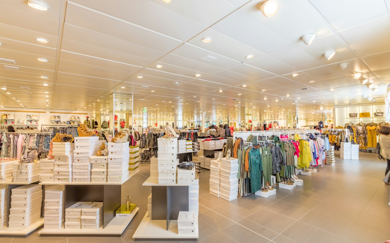 Sade renklerde kıyafetlerin asılı olduğu butik giyim mağazası