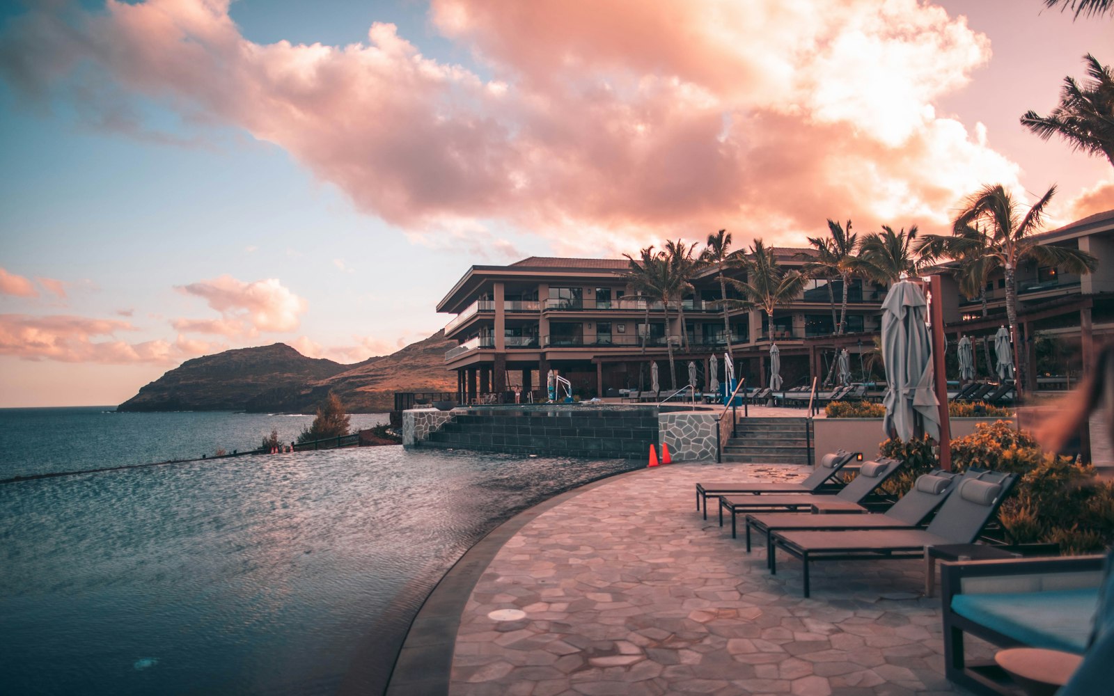 Gün batımında deniz kıyısında sonsuzluk havuzlu resort otel